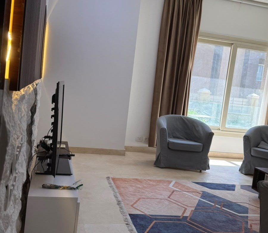 Living room by balcony, The Village apartment for sale | معيشة بجوار البلكونة، شقة للبيع في ذا فيلدج
