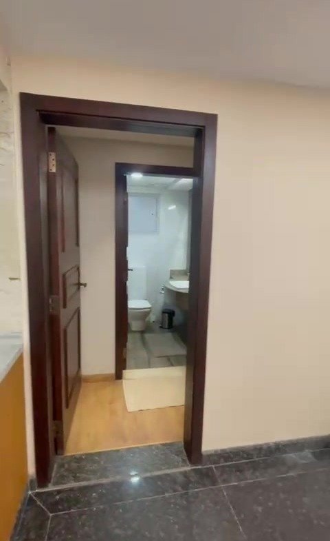 Tall mirror beside a dark wooden door - hotel apartment in Marassi