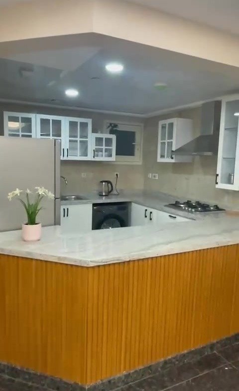 Kitchen island with a wooden front and white cabinets - hotel apartment in Marassi