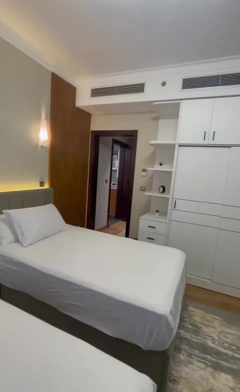 Bedroom with a white cover and a wall TV - hotel apartment in Marassi