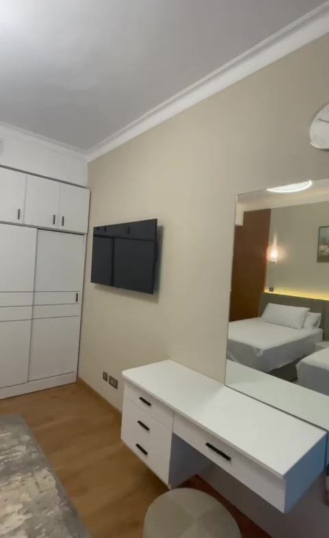 Bedroom with a white vanity and a mirrored wardrobe - hotel apartment in Marassi