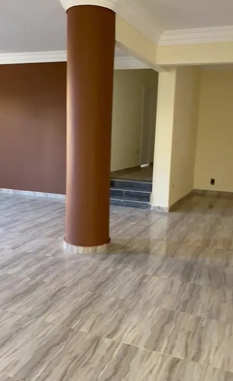 Open space with a brown round column and a wood-look floor - apartment in 2nd District, 5th Settlement