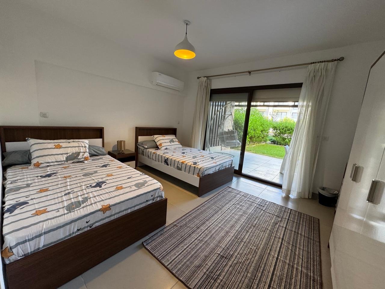 Bedroom with twin beds and garden access, chalet for rent in Marassi Marina Residences, North Coast | غرفة نوم بسريرين ومدخل الحديقة، شاليه للإيجار في مراسي مارينا ريزيدنس، الساحل الشمالي