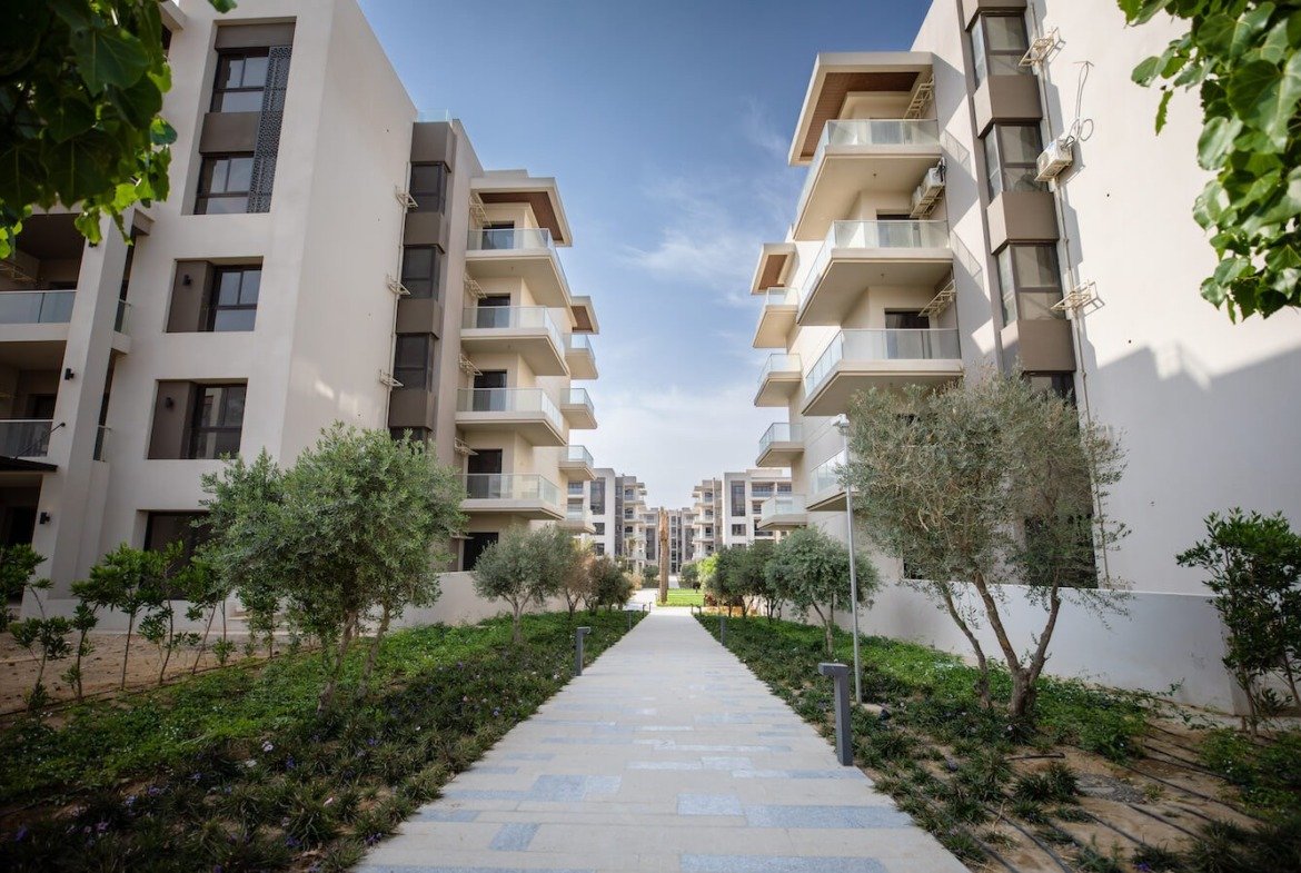 Walkway between apartment buildings, The Address East, New Cairo - general project photo for apartment for sale | ممر بين المباني السكنية، ذا أدريس إيست، القاهرة الجديدة - صورة عامة للمشروع لشقة للبيع