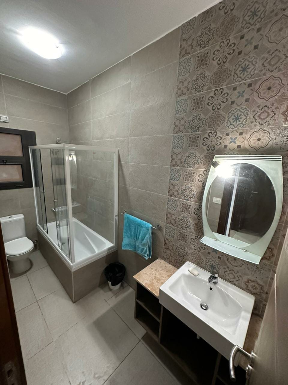 Fifth Square apartment 514-03 Bathroom with glass shower and round mirror - apartment in Golden Square, Fifth Square, New Cairo