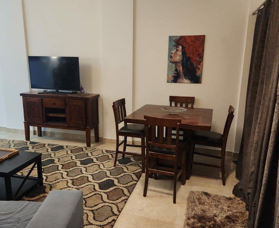 Living room with dining table and television - apartment in Golden Square, Fifth Square, New Cairo