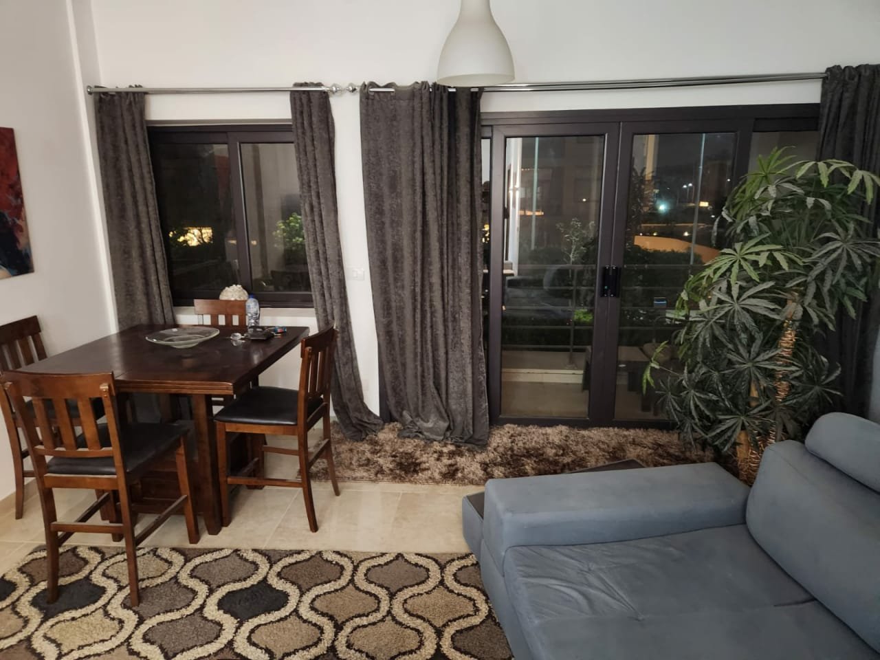 Fifth Square apartment 514-06 Dining table and sofa beside the balcony doors - apartment in Golden Square, Fifth Square, New Cairo