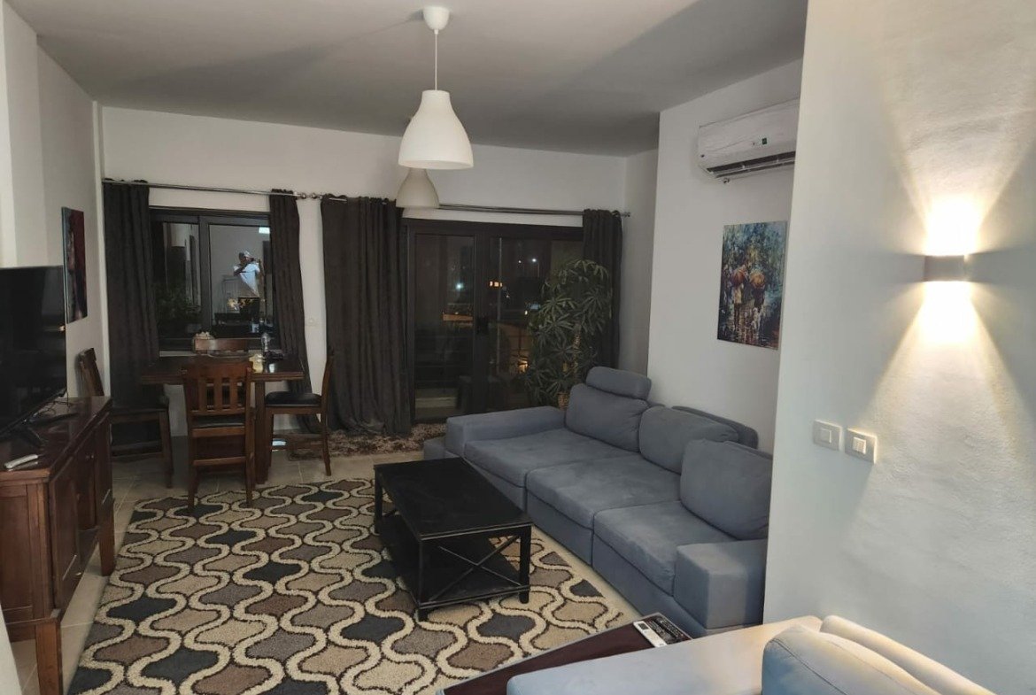 Living room with grey sofa and wall light - apartment in Golden Square, Fifth Square, New Cairo
