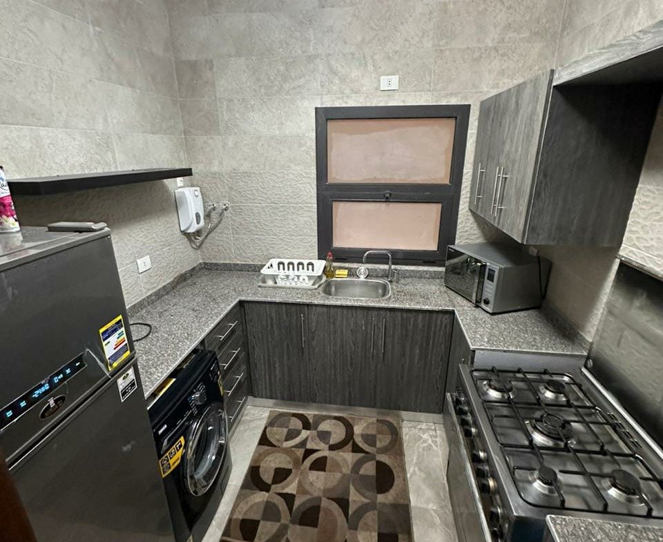 Kitchen with grey tiles and gas hob - apartment in Golden Square, Fifth Square, New Cairo