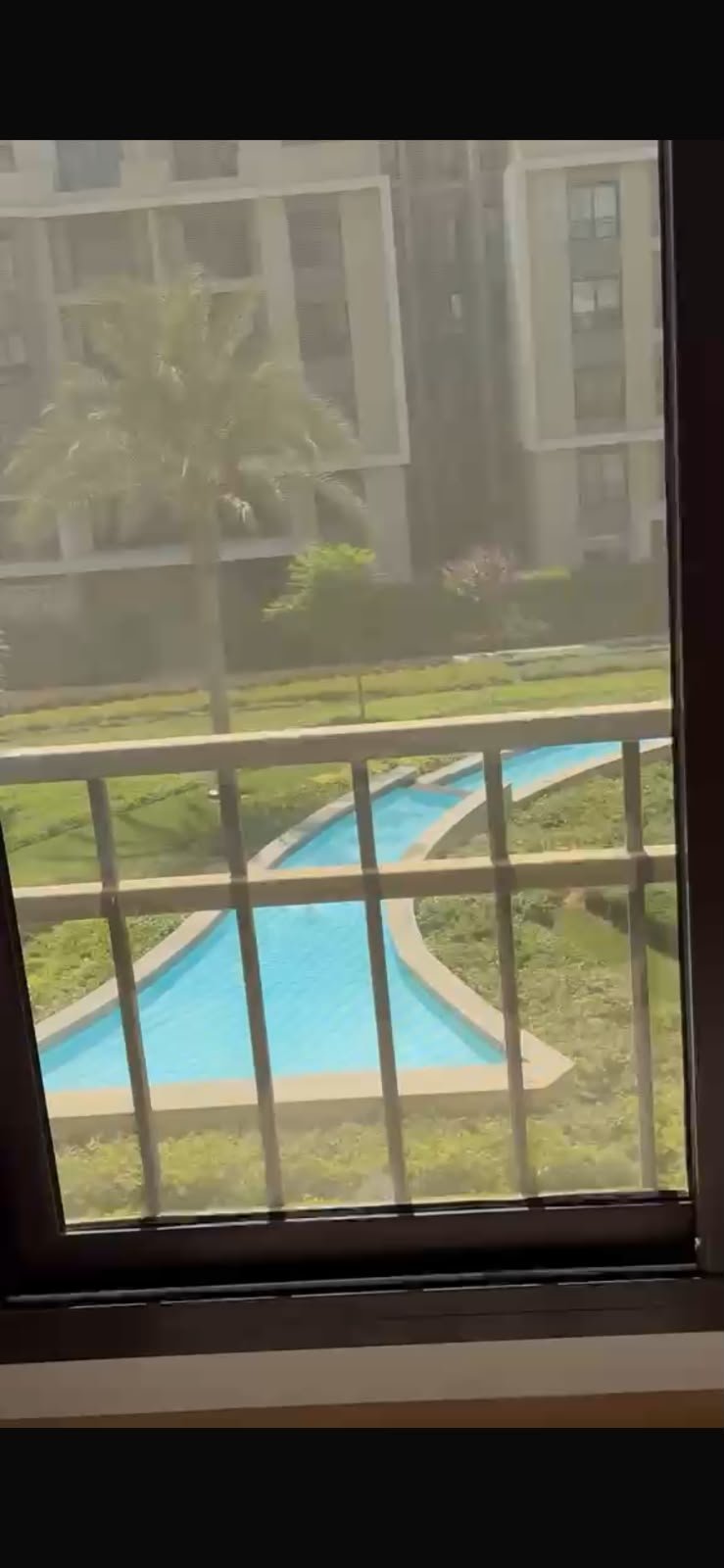 5th-square-apartment-for-rent-461-08 Pool seen through the balcony railing - apartment in Fifth Square, New Cairo