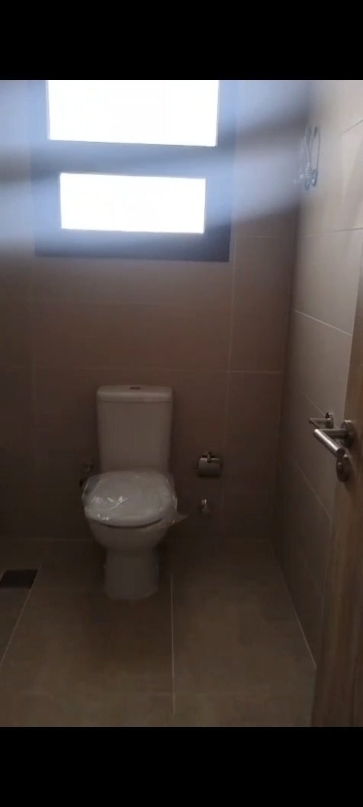 Toilet in a small bathroom with skylight - apartment in Fifth Square, New Cairo