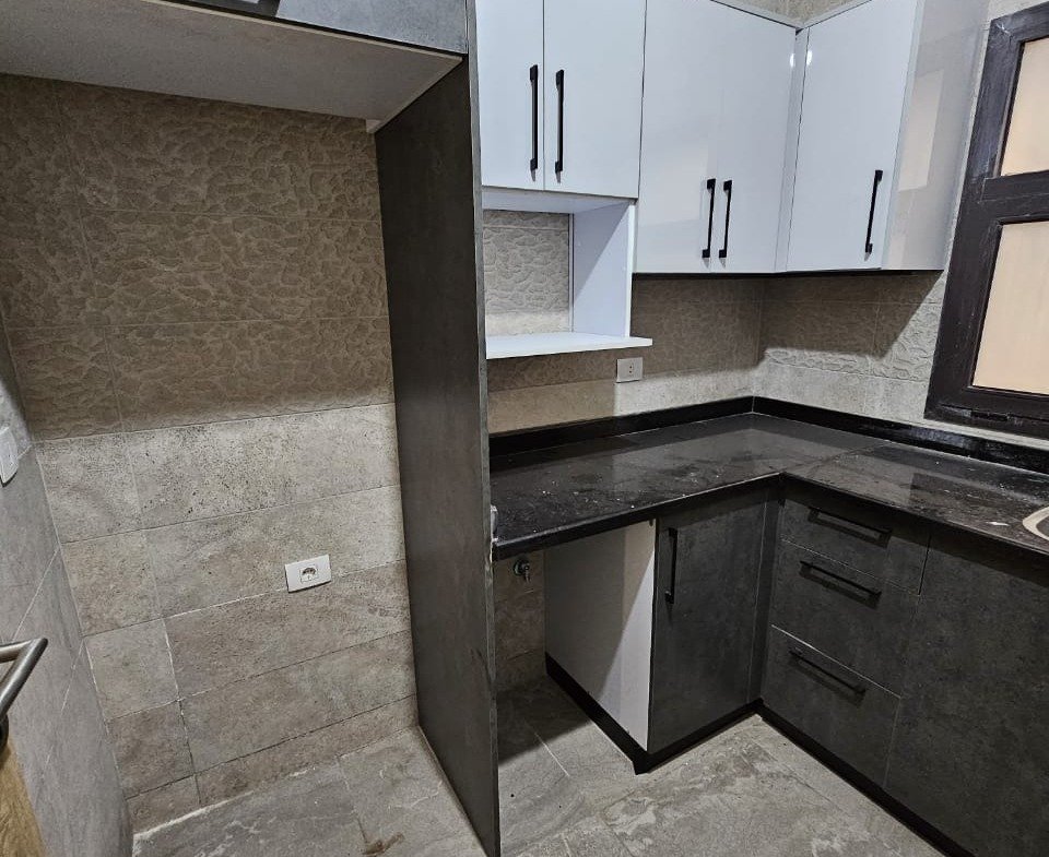 Kitchen corner with white cabinets - studio in Fifth Square, New Cairo