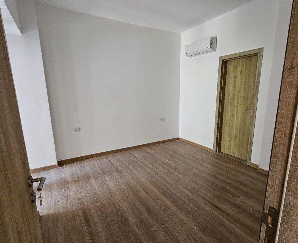 Empty bedroom with wooden floor and door - studio in Fifth Square, New Cairo