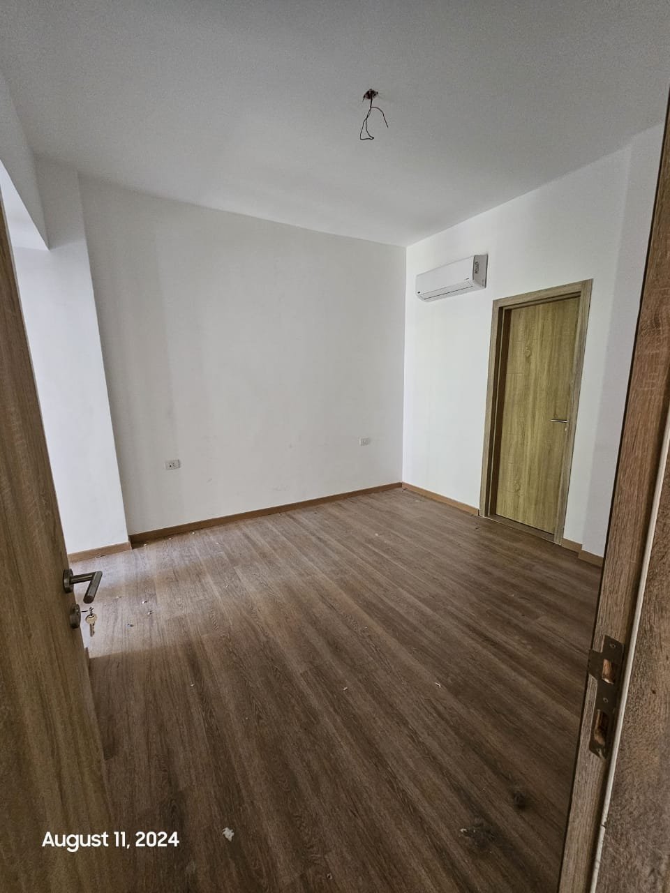 Empty bedroom with wooden floor and door - studio in Fifth Square, New Cairo