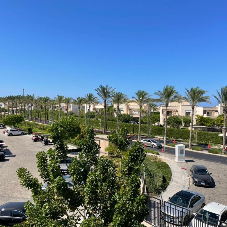 Daytime view of landscaped surroundings, second-floor chalet for rent in Marassi Marina 1, Sidi Abd El Rahman, North Coast - R&C Estate | إطلالة نهارية على المساحات الخضراء المحيطة، شاليه دور ثانٍ للإيجار في مراسي مارينا 1، سيدي عبد الرحمن، الساحل الشمالي - R&C Estate