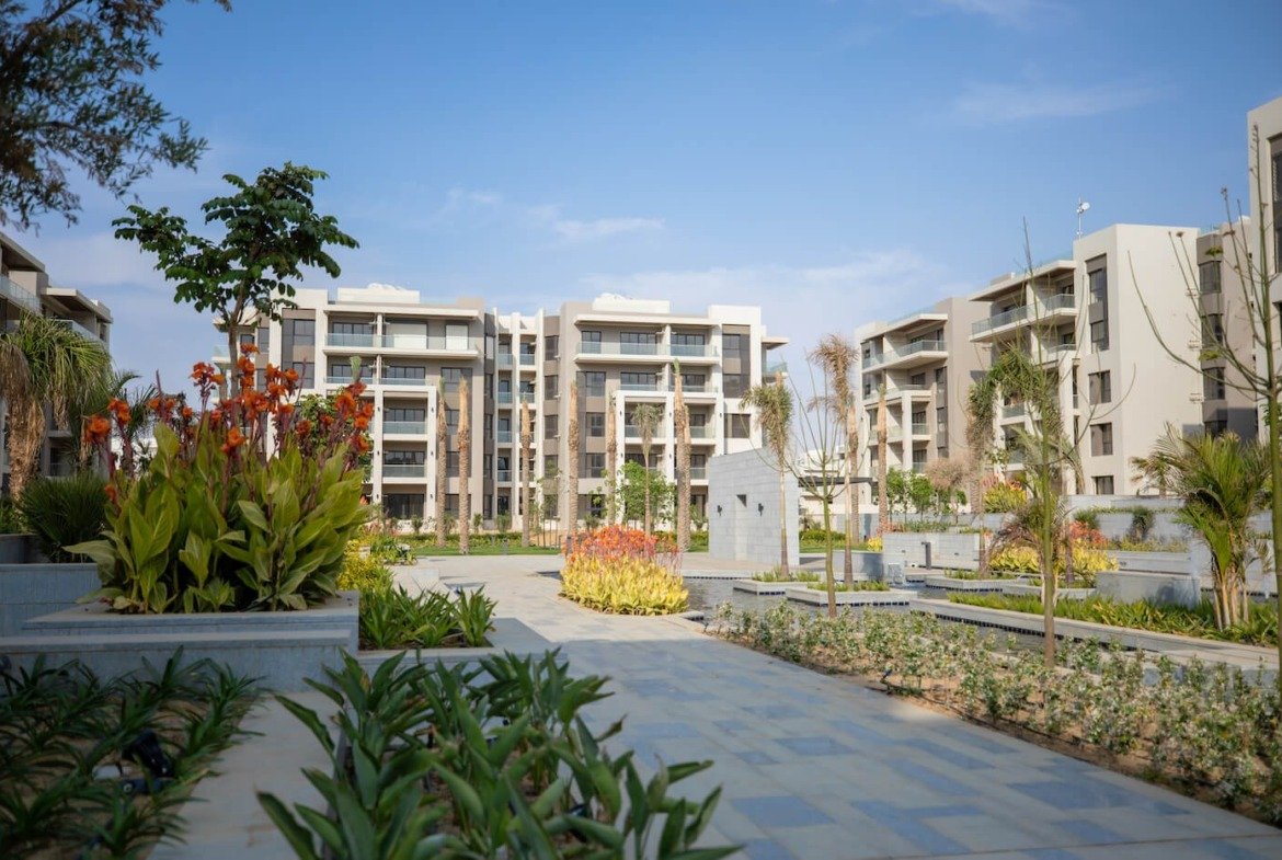 Landscaped gardens between residential buildings, The Address East, New Cairo - general project photo for apartment for sale | حدائق منسقة بين المباني السكنية، ذا أدريس إيست، القاهرة الجديدة - صورة عامة للمشروع لشقة للبيع