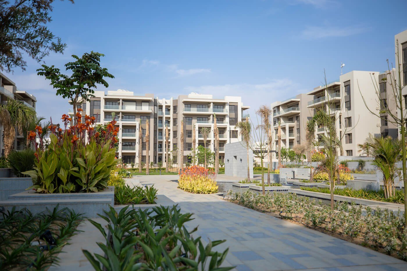 Landscaped gardens between residential buildings, The Address East, New Cairo - general project photo for apartment for sale | حدائق منسقة بين المباني السكنية، ذا أدريس إيست، القاهرة الجديدة - صورة عامة للمشروع لشقة للبيع
