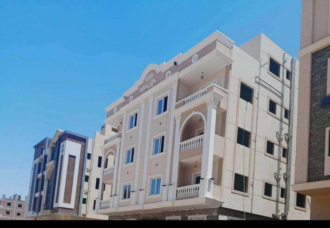 Angled exterior view of the building and nearby street, Bayt Al Watan District 2, Fifth Settlement, penthouse for sale | واجهة المبنى من زاوية والشارع المجاور، بيت الوطن الحي الثاني، التجمع الخامس، بنتهاوس للبيع