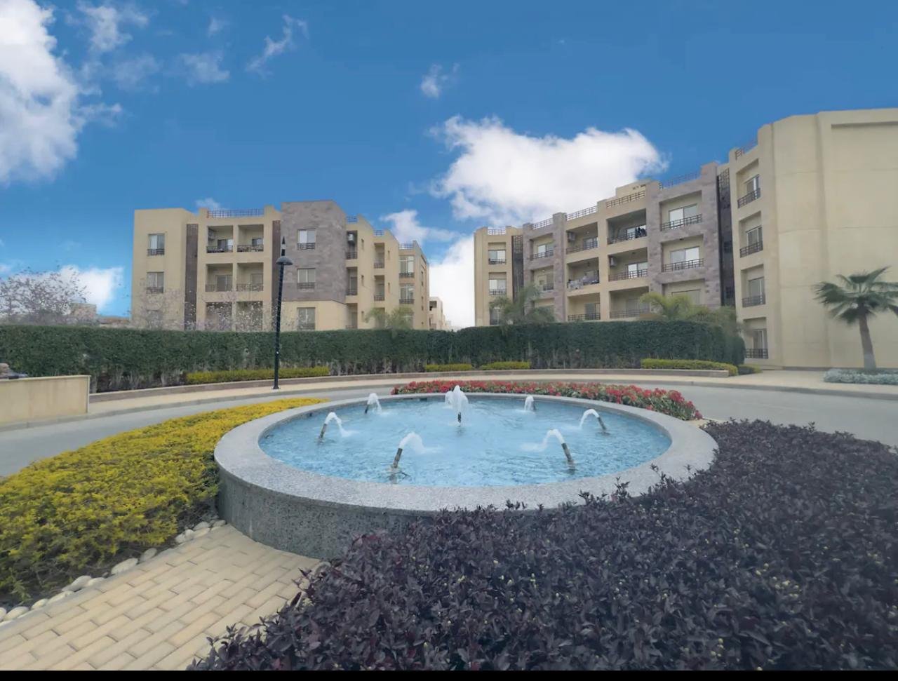 akoya-513-14 Landscaped fountain with apartment buildings behind - apartment in Akoya, New Cairo