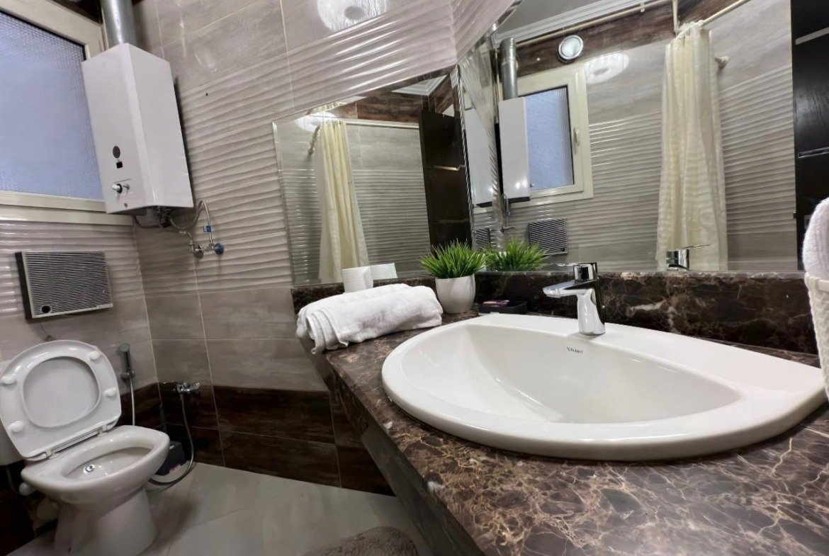 Bathroom with a round basin and a marble counter - apartment in Akoya, New Cairo