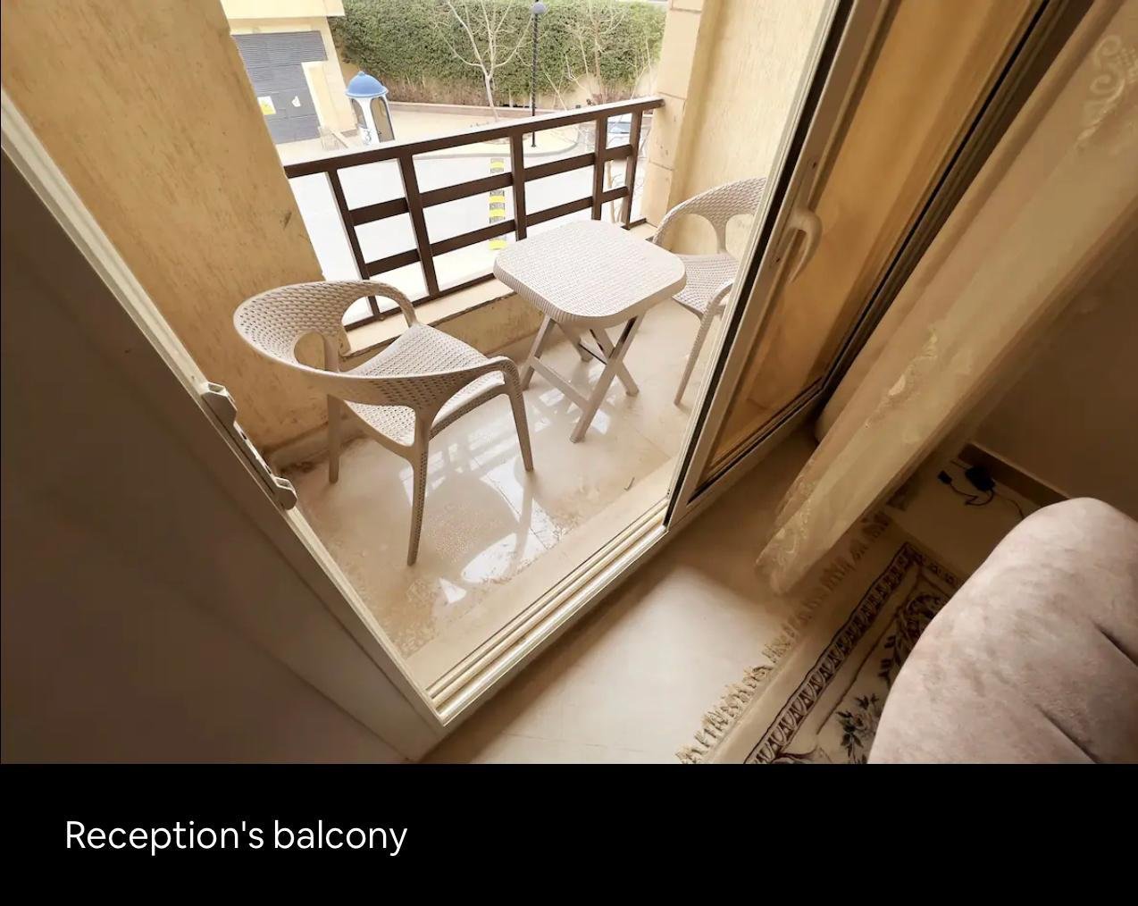 akoya-513-16 Small balcony with two chairs and a table - apartment in Akoya, New Cairo