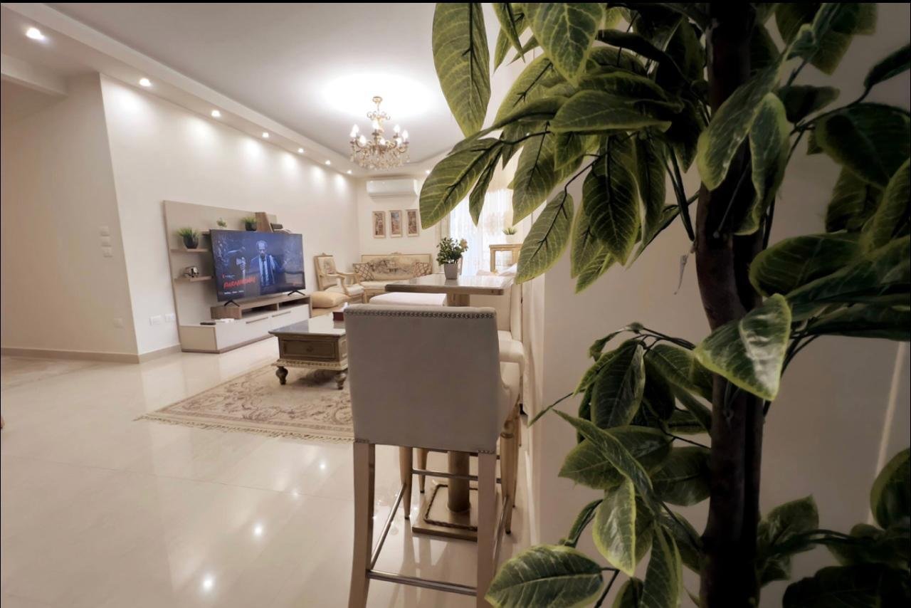 akoya-513-17 Living area with a high stool and an indoor plant - apartment in Akoya, New Cairo