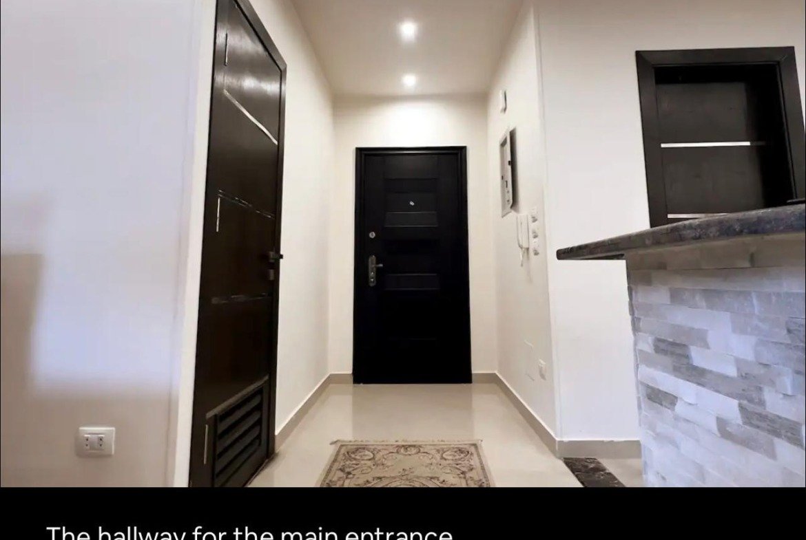 Entrance hallway with a dark front door - apartment in Akoya, New Cairo