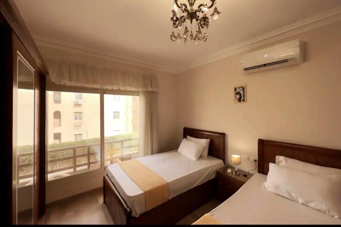 Bedroom with two beds and a balcony view - apartment in Akoya, New Cairo