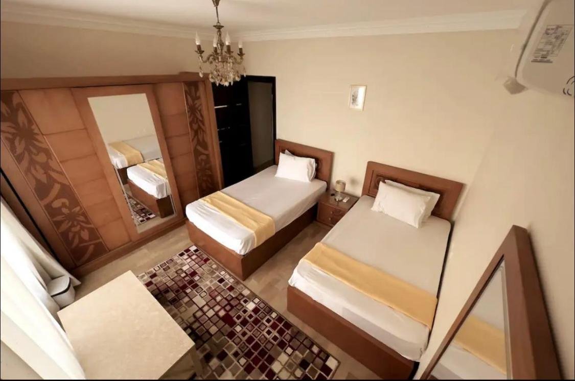 Twin beds with gold bedspreads and a carved wardrobe - apartment in Akoya, New Cairo