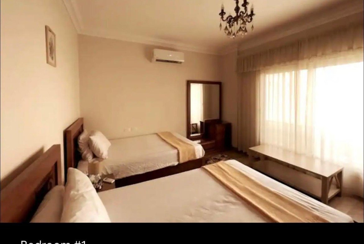 Bedroom with a striped bed runner and sheer curtains - apartment in Akoya, New Cairo