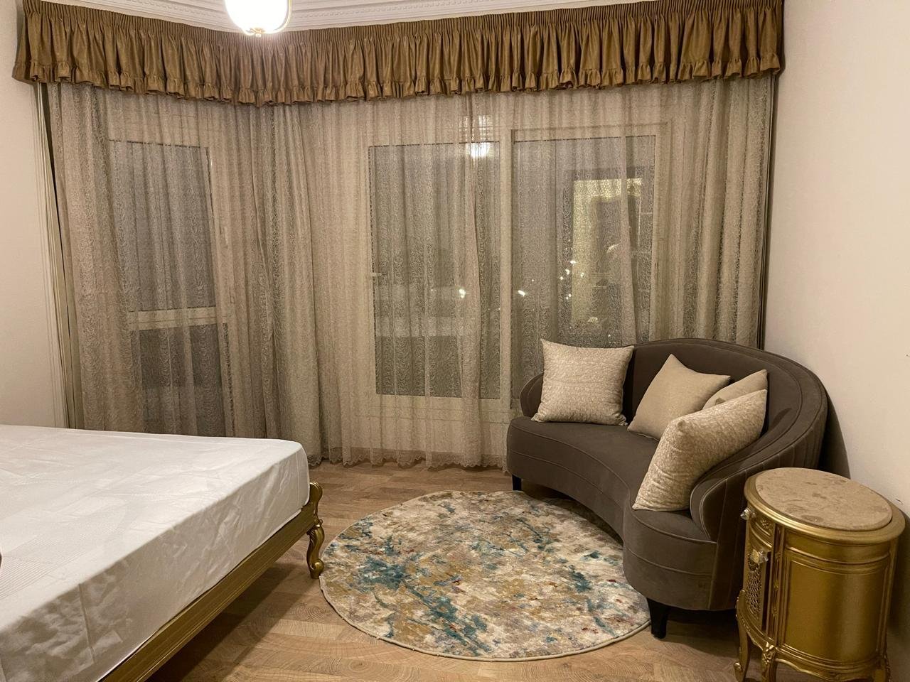akoya-513-28 Bedroom with a curved armchair and a patterned rug - apartment in Akoya, New Cairo