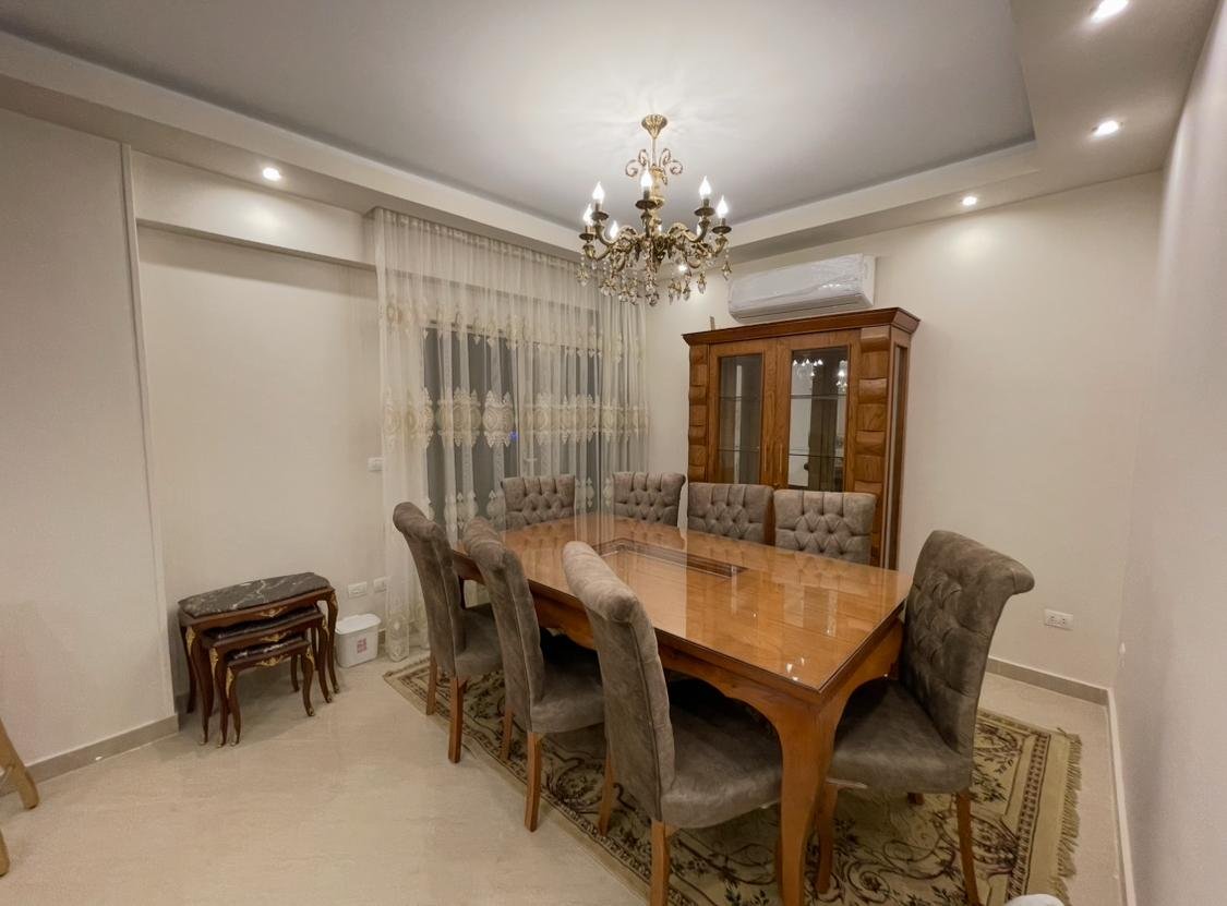 akoya-513-3 Dining room with a wooden table and a carved display cabinet - apartment in Akoya, New Cairo