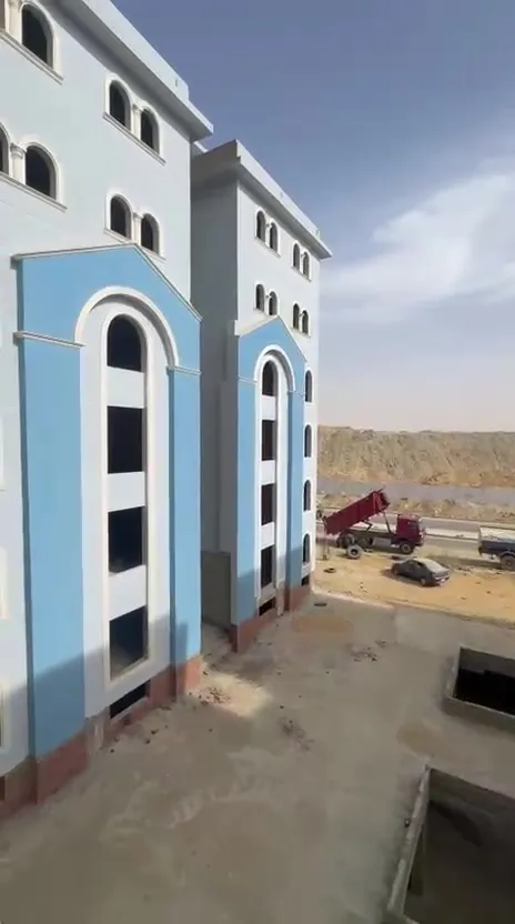 عمارة بيضاء وزرقاء بجوار أرض فضاء - شقة في كمبوند النخيل التجمع الخامس، القاهرة الجديدة