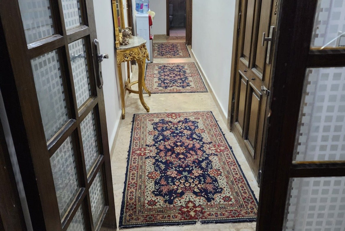 Hallway with glass-panel doors and a long runner rug - apartment in Al Narges, New Cairo
