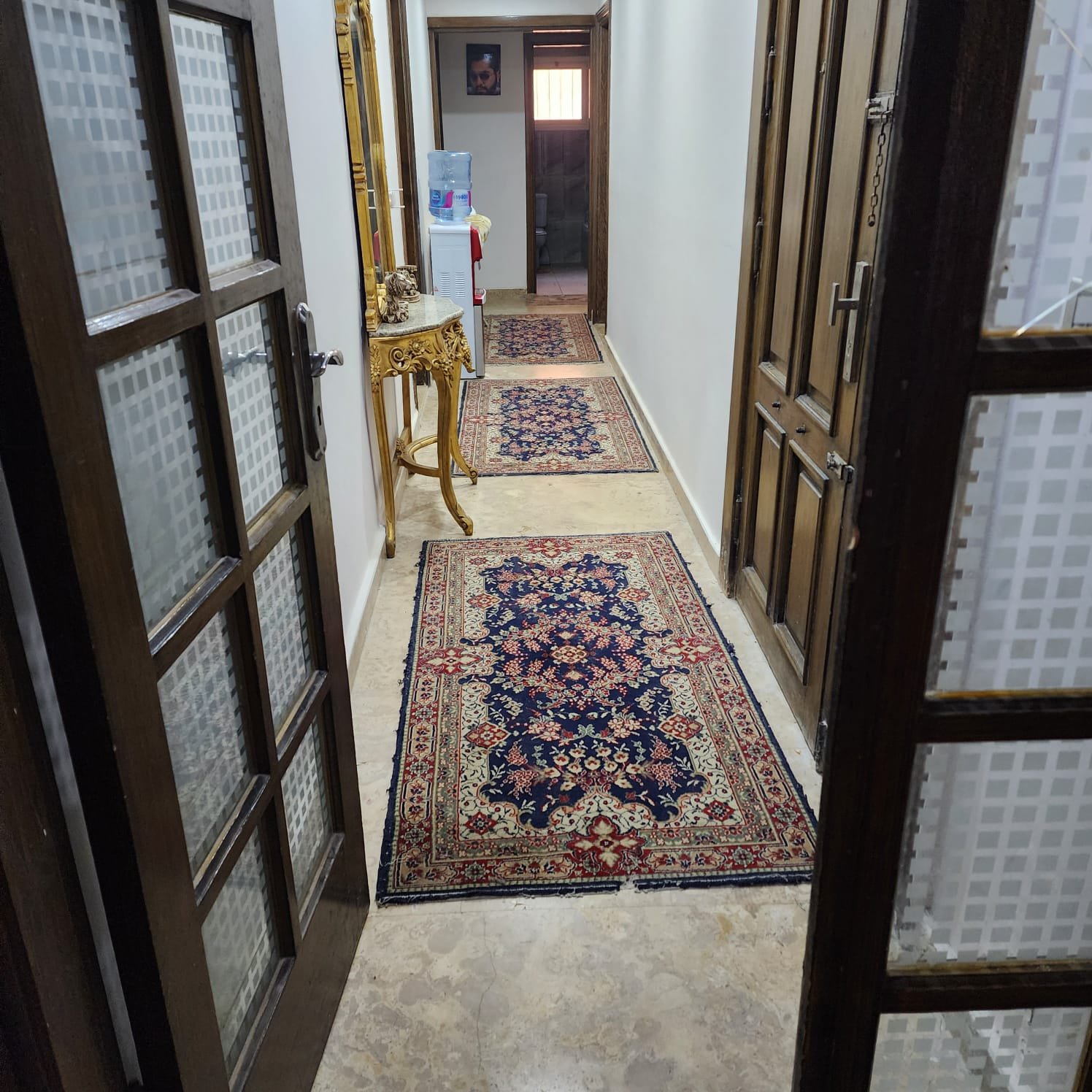 Hallway with glass-panel doors and a long runner rug - apartment in Al Narges, New Cairo