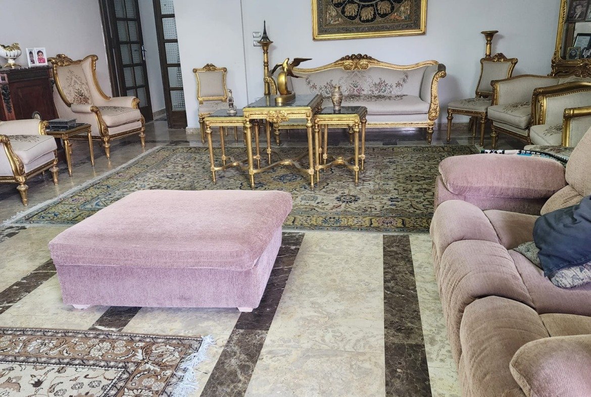 Sitting area with a pink ottoman and an ornate rug - apartment in Al Narges, New Cairo