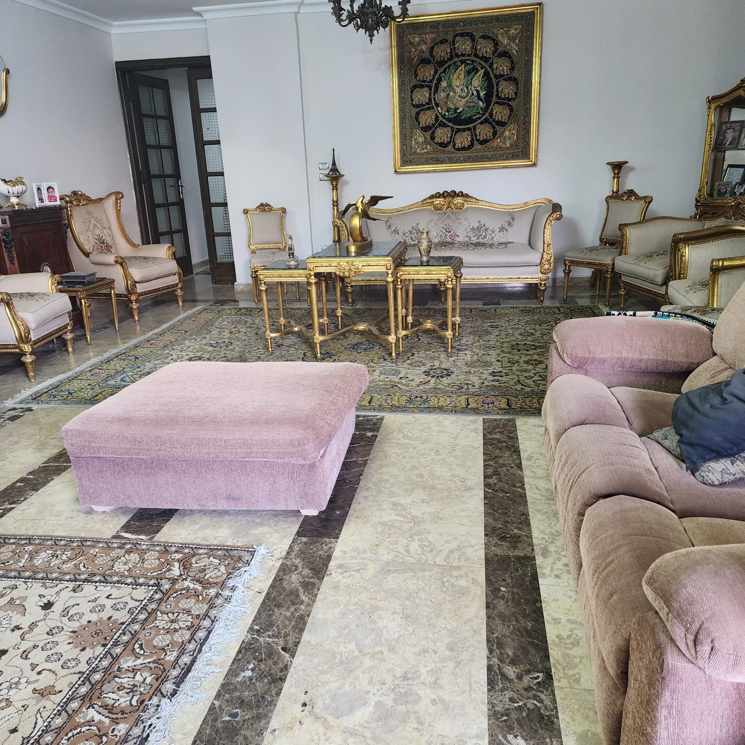 Sitting area with a pink ottoman and an ornate rug - apartment in Al Narges, New Cairo