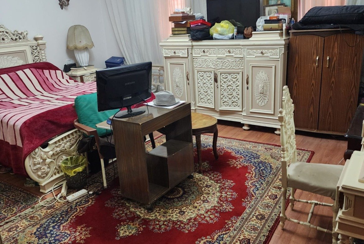 Bedroom with a red rug, a work desk and a white dresser - apartment in Al Narges, New Cairo