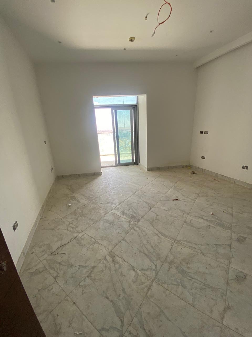 Empty room with a single window and marble floor - chalet in Alamein Towers