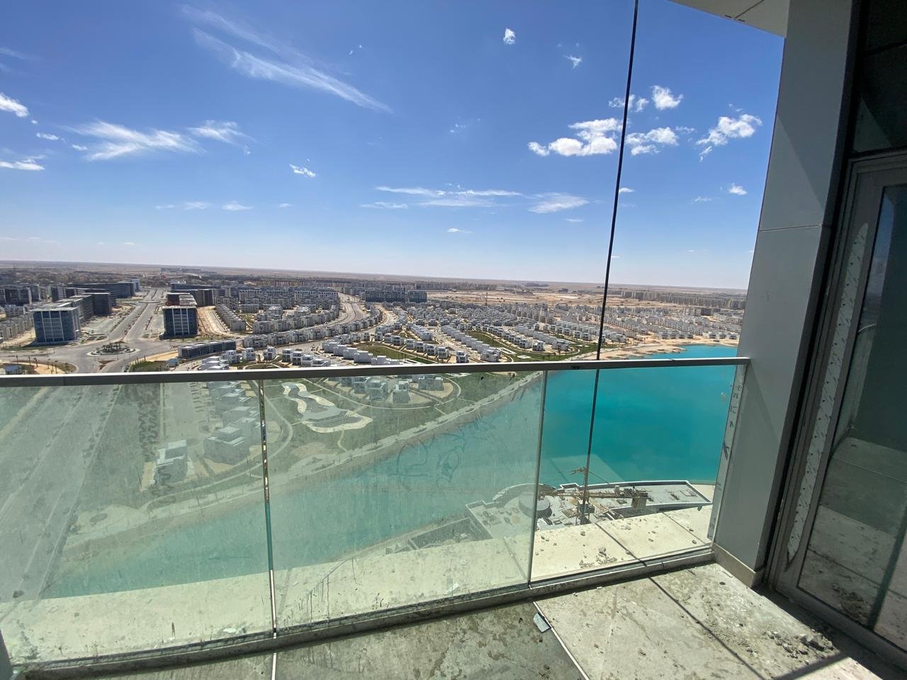Balcony with a frameless glass railing over the lagoon - chalet in Alamein Towers