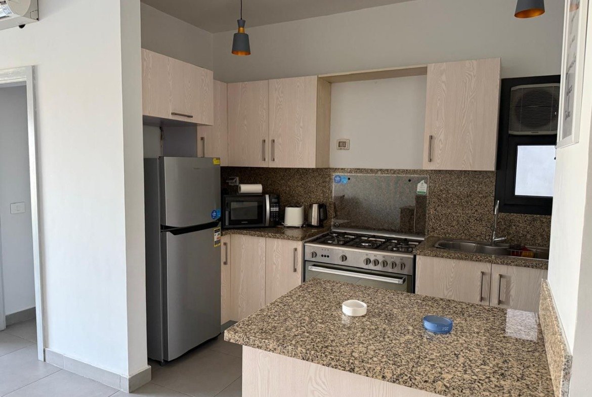 Modern kitchen with a granite breakfast counter - apartment in Alburouj, Shorouk City