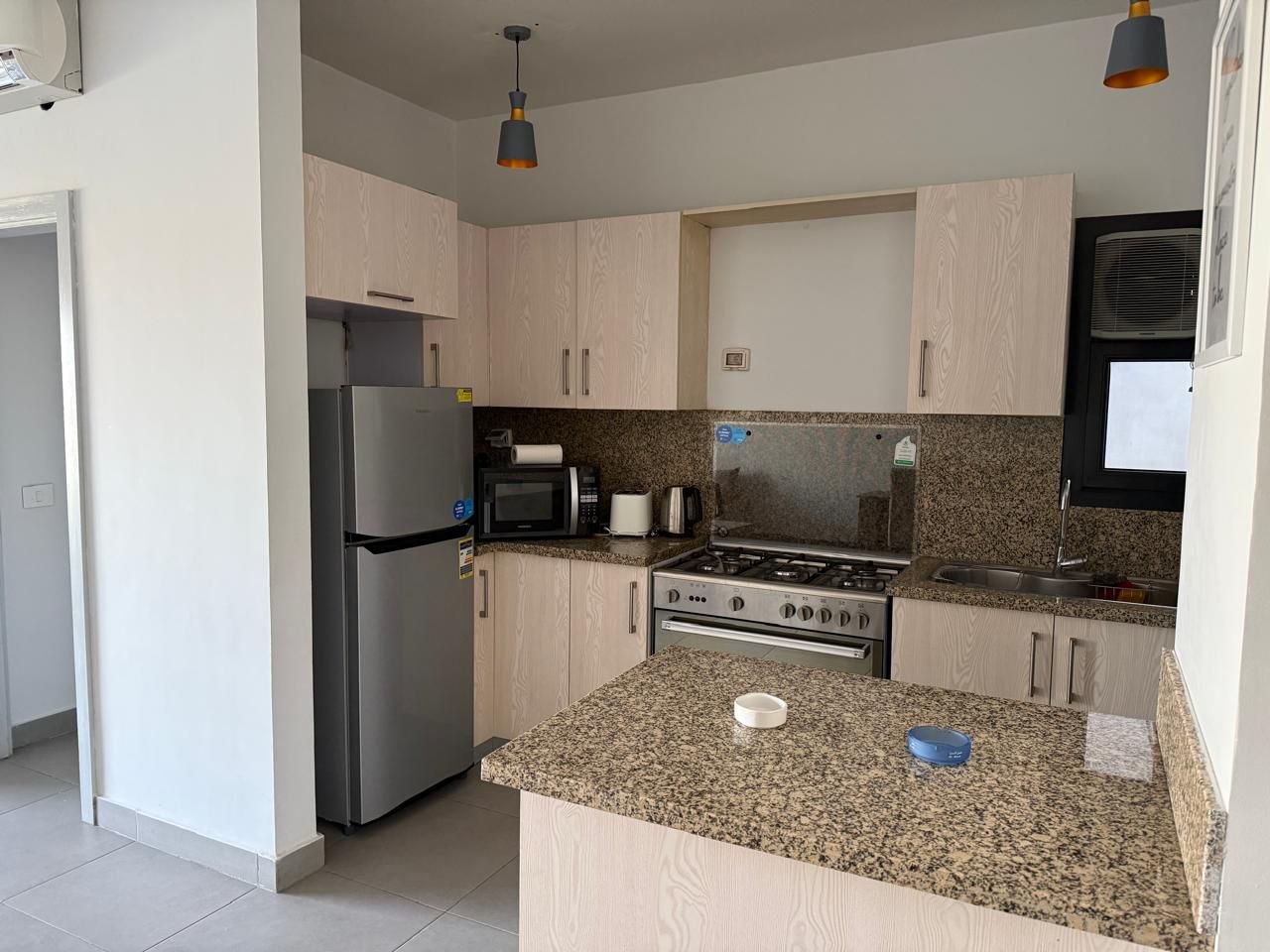 Modern kitchen with a granite breakfast counter - apartment in Alburouj, Shorouk City