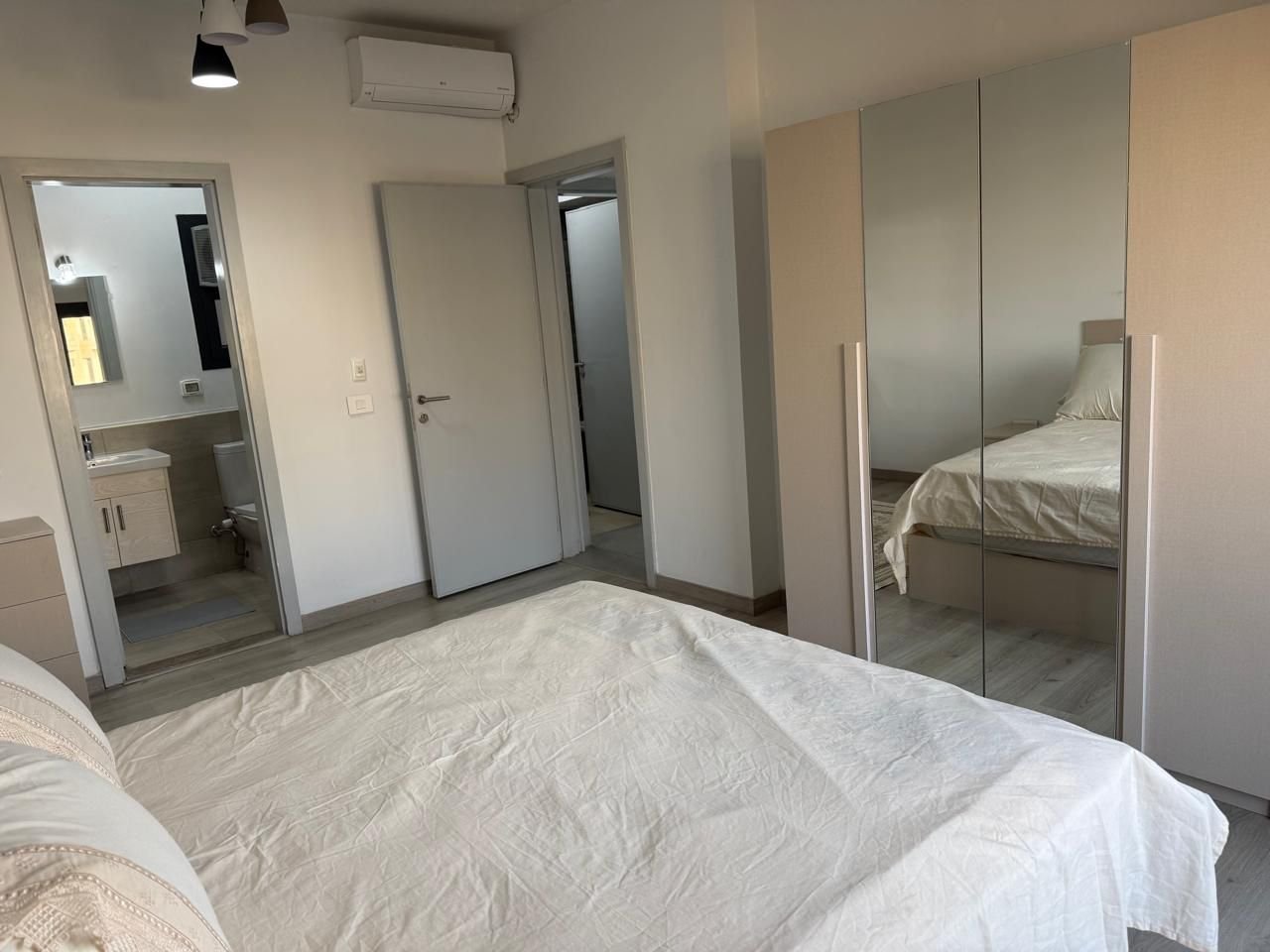 Bedroom with a fitted wardrobe and en-suite bathroom - apartment in Alburouj, Shorouk City