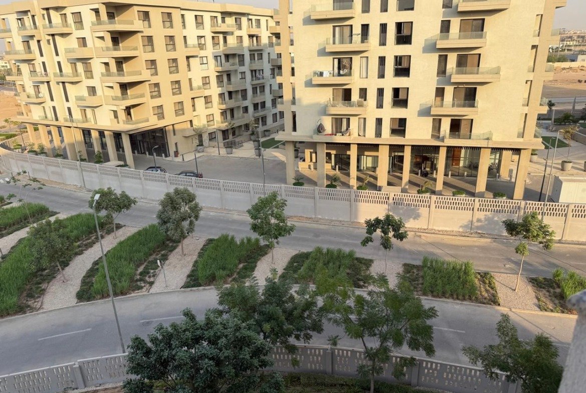 View over yellow apartment buildings and gardens - apartment in Alburouj, Shorouk City