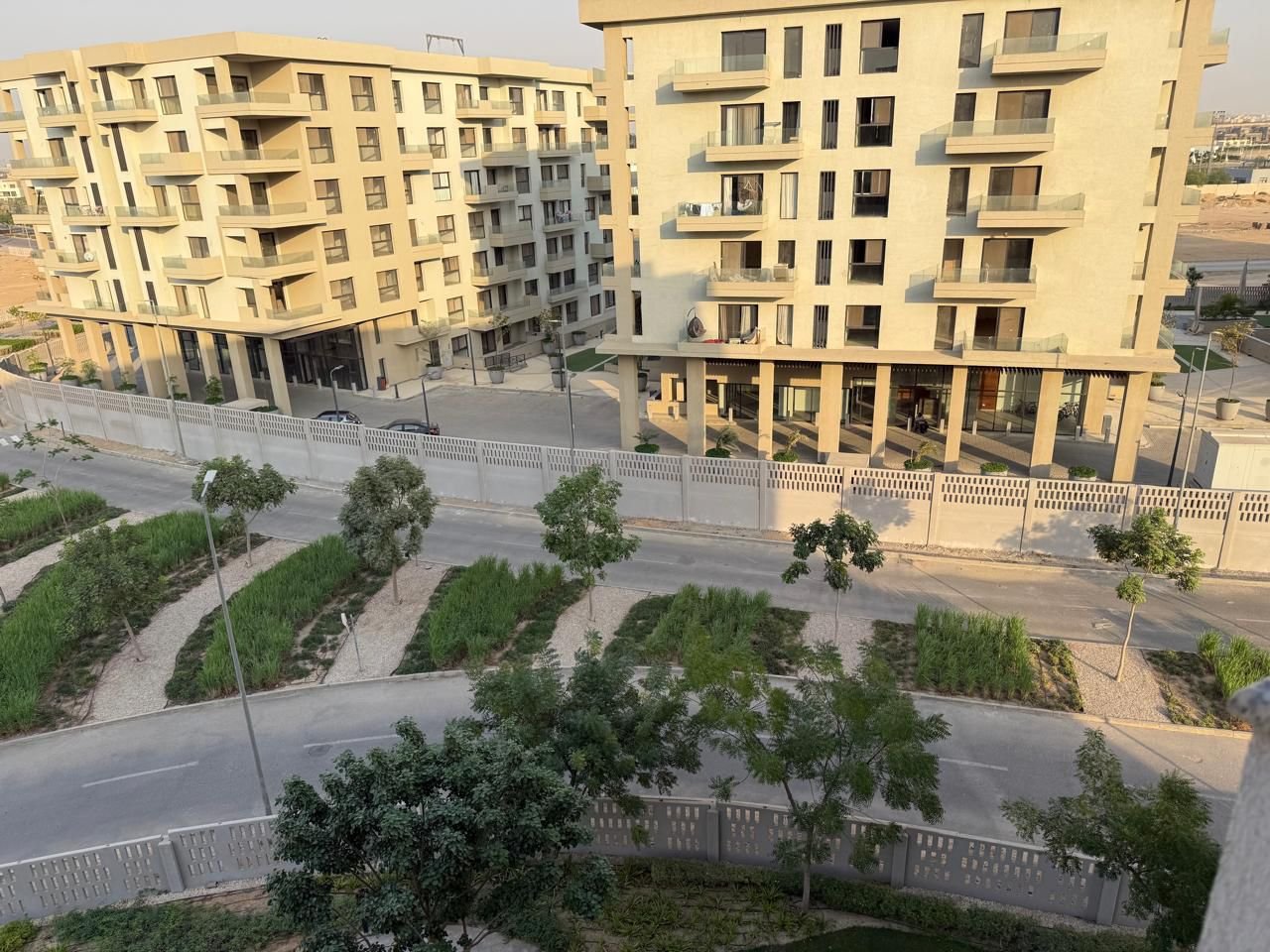 View over yellow apartment buildings and gardens - apartment in Alburouj, Shorouk City