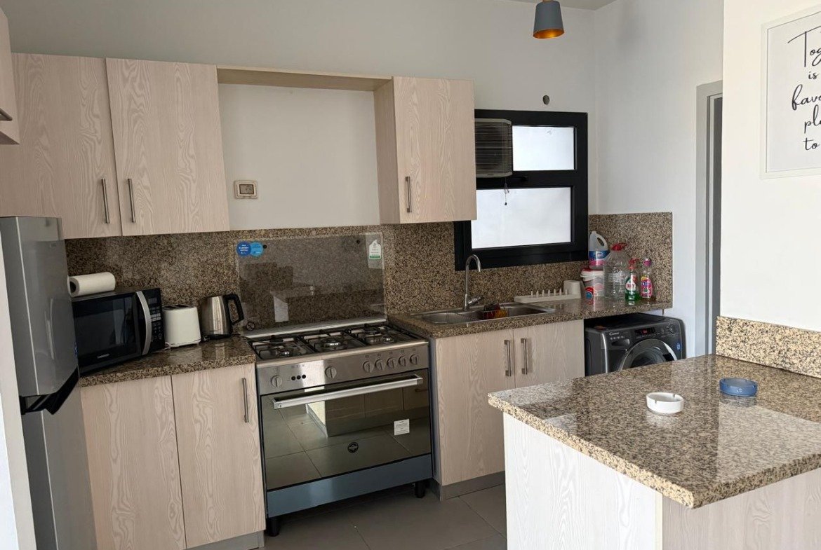 Kitchen with a breakfast bar and pendant lights - apartment in Alburouj, Shorouk City