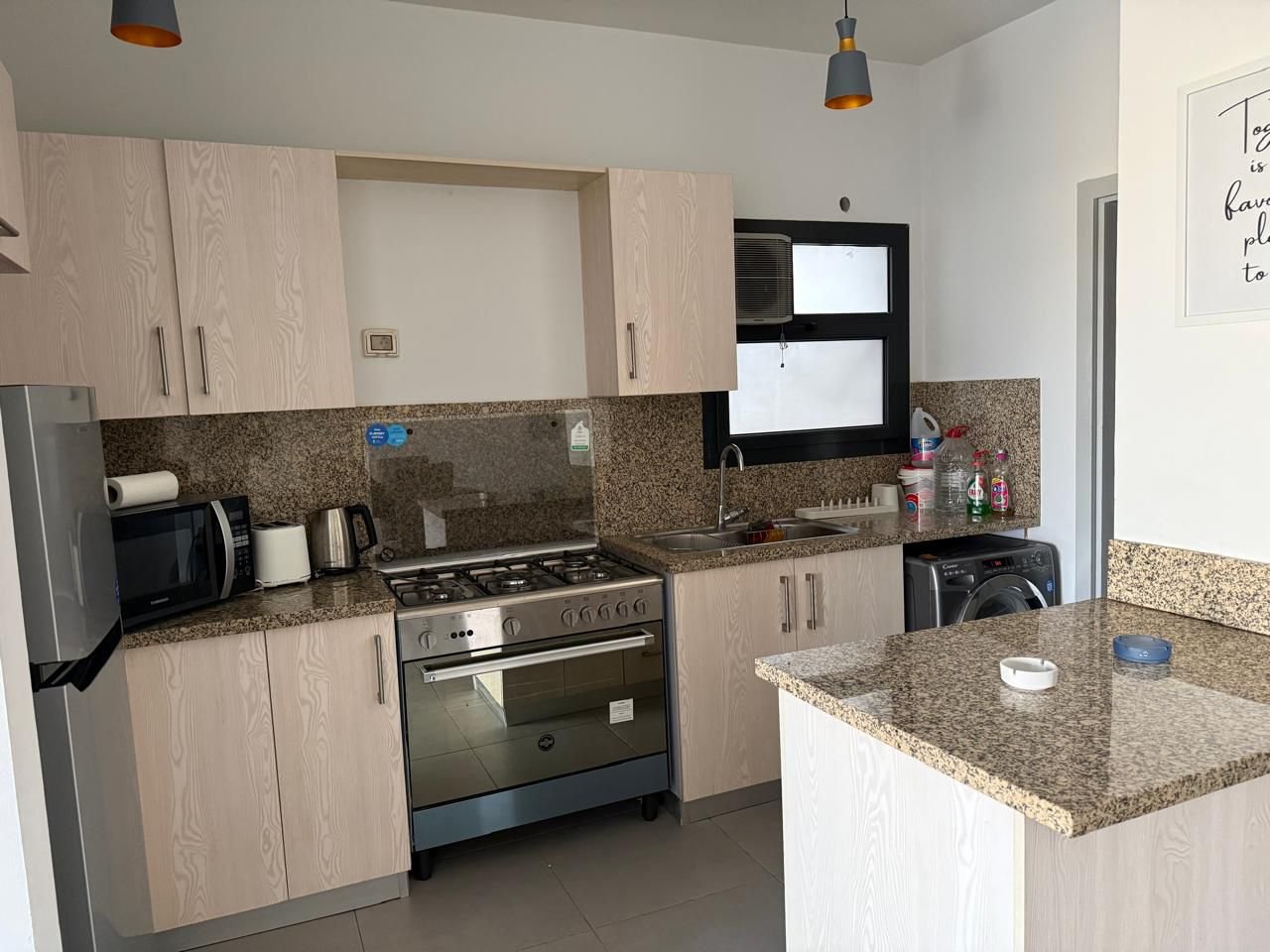 Kitchen with a breakfast bar and pendant lights - apartment in Alburouj, Shorouk City