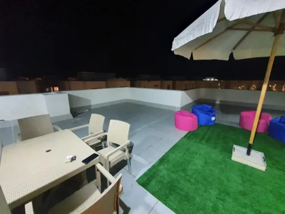 Roof terrace with umbrella and seating in Amwaj at night