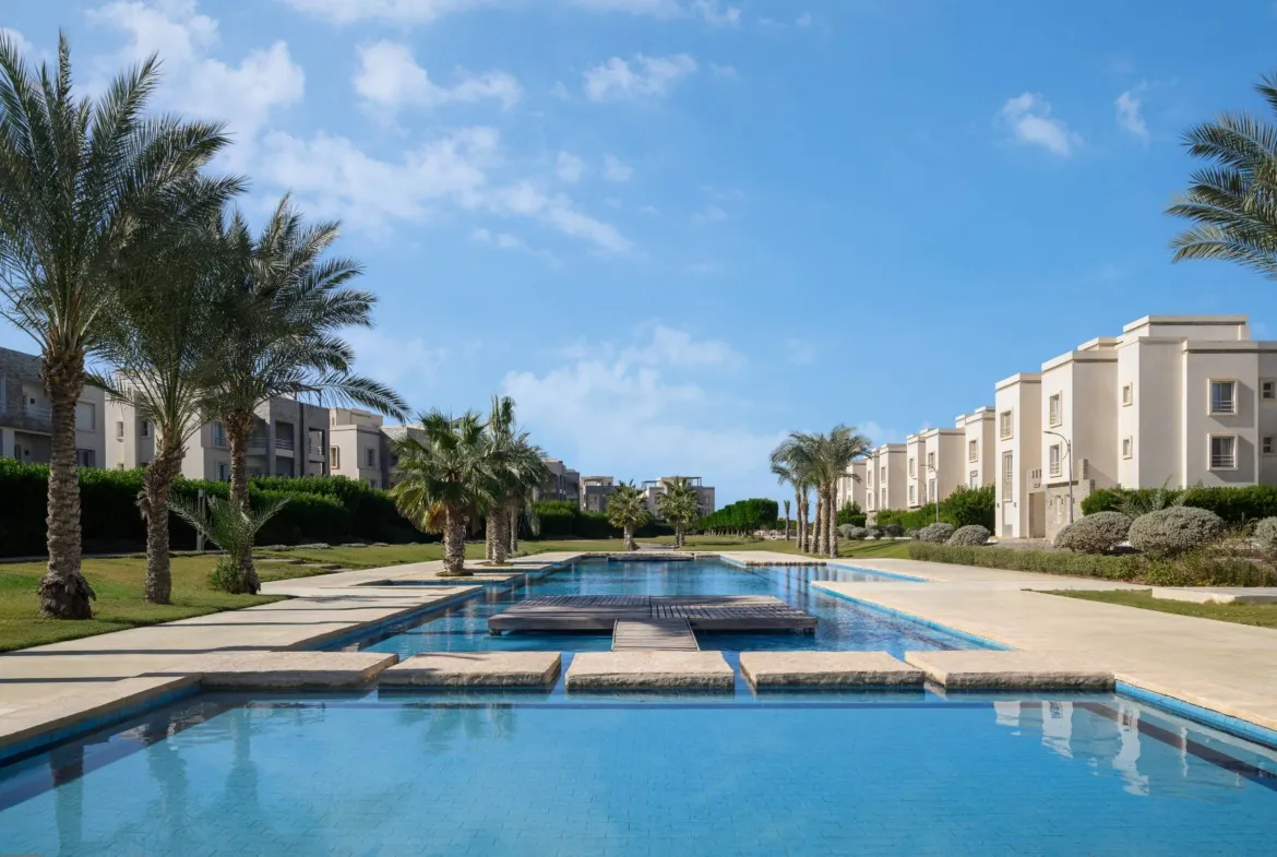 Pool with stepping platforms beside white apartment blocks - chalet in Amwaj, North Coast