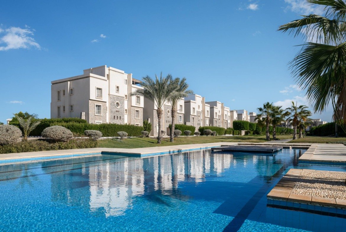 White apartment buildings reflected in a clear pool - chalet in Amwaj, North Coast